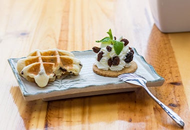 Waffle emplatado acompañado de una galleta y crema batida 