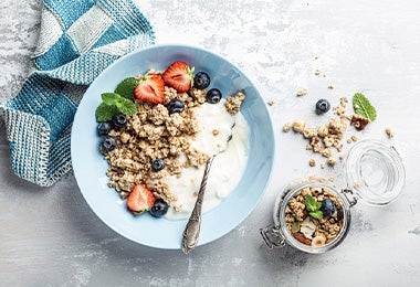 Plato de yogurt griego con granola y frutas para el desayuno