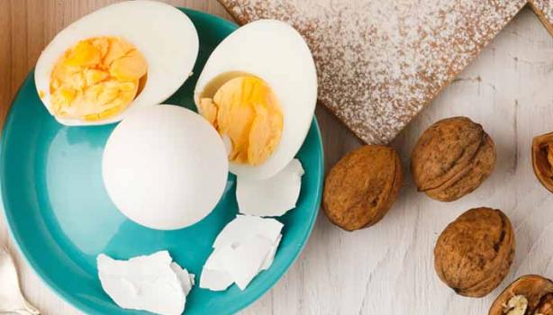 Huevos cocidos, acompañados por jugo de naranja y un croissant.