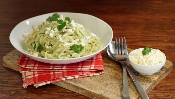 Pasta aromatizada con cilantro, servida en un plato blanco.