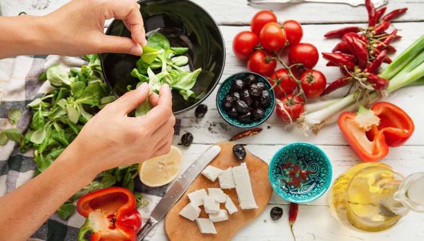 Aceite de oliva, queso, frutas cítricas y jitomates para una ensalada griega, una comida mediterránea.