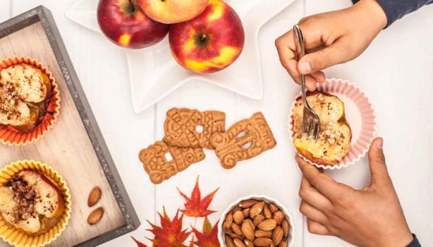 Persona comiendo postre de manzana asada con galletas 