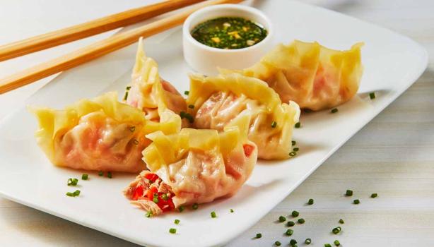 Plato con dumplings de atún, salsa y palitos chinos 