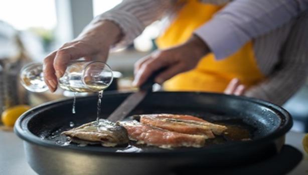 Mujer cocinando pescado