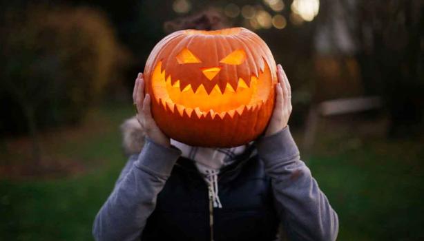 Calabaza de Halloween sobre el cuerpo de una persona. 