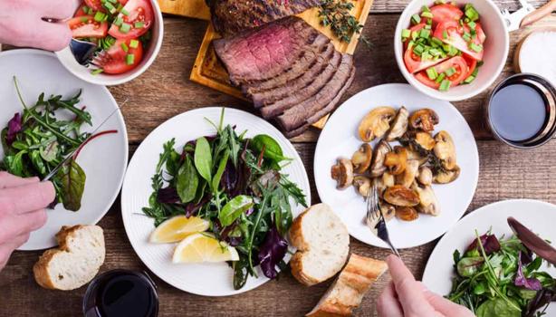 Mesa con comida y cuántas calorías se deben consumir al día según tus actividades y dieta.