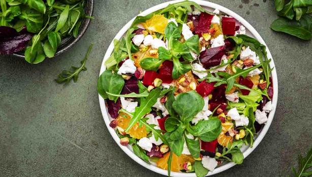 Ensalada en cenital con hojas verdes, remolacha, queso y frutos cítricos, un plato que puedes conservar en casa