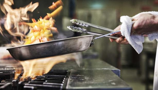 Sartén con fuego, importancia conocer primeros auxilios en la cocina 
