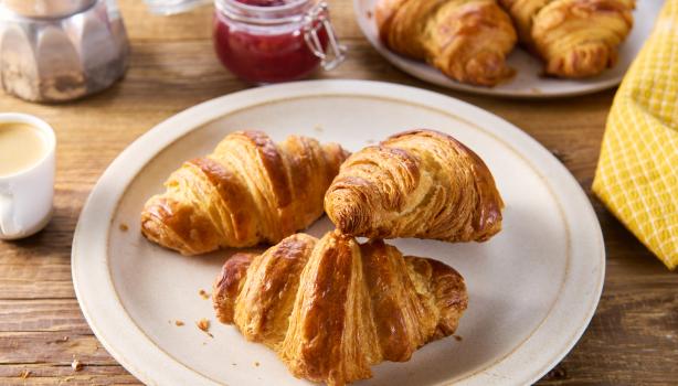 Tres deliciosos croissants de almendras frescos sobre un plato.