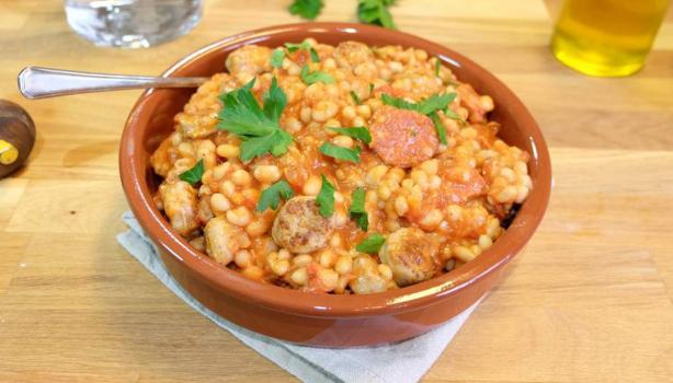 Cassoulet tradicional servido en cazuela de barro con alubias y salchicha