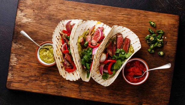 Tortilla de dieta llena de vegetales sobre tabla de picar. 