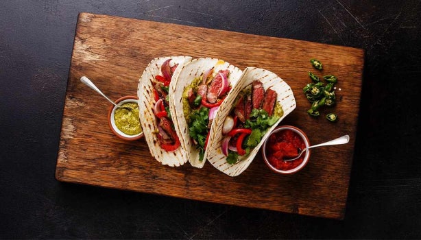 Fajitas de bistec a la parrilla con tortillas de taco y salsa, el origen de los tacos.