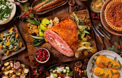 Un jamón de pavo acompañado de diferentes guarniciones navideñas.