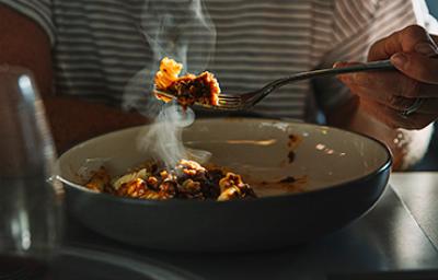 La pasta es una de las comidas fáciles de hacer. Una persona comiendo un plato de pasta, una de las comidas fáciles de hacer.