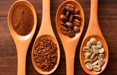 Cucharones de madera con café en polvo y grano