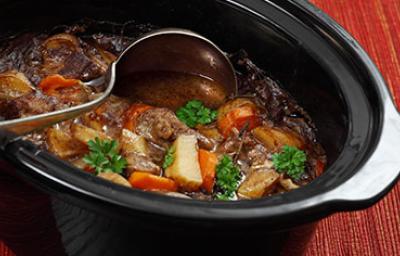 Estofado de carne y verduras siendo preparado en una olla de cocción lenta.