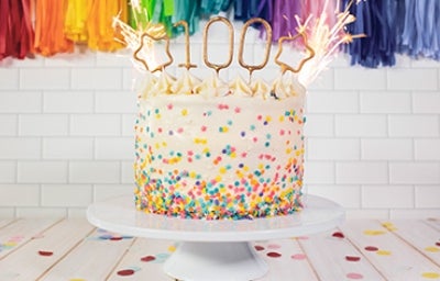 Pastel de cumpleaños con chispas de colores y vela Pastel de cumpleaños con chispas de colores y vela