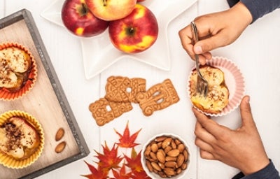 Persona comiendo postre de manzana asada con galletas Persona comiendo postre de manzana asada con galletas