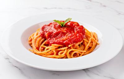 Espagueti con salsa pomodoro, servido en un plato blanco. 