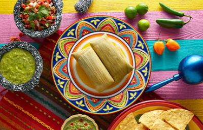 Los tamales son un plato común en los libros de cocina de América Latina. Tamales sobre una mesa, un plato común en los libros de cocina de América Latina.