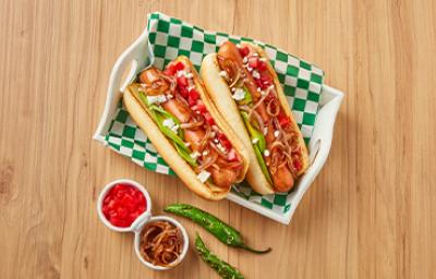 Plato con hot dogs, cebollas caramelizadas, jitomates y chiles Plato con hot dogs, cebollas caramelizadas, jitomates y chiles