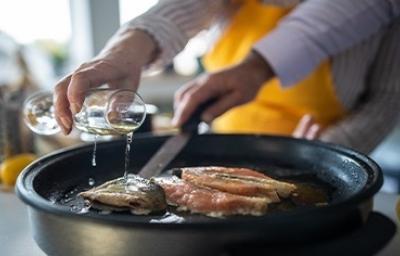 Mujer cocinando pescado Mujer cocinando pescado