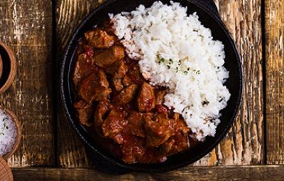 Carne en cuadros y arroz blanco en una sartén de hierro. Carne en cuadros y arroz blanco en una sartén de hierro.