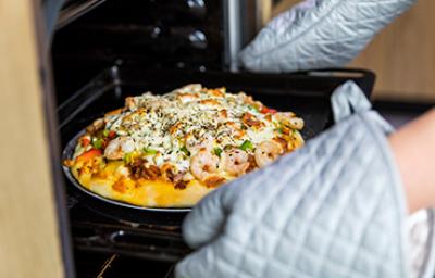 Sacar receta del horno utilizando guantes y agarraderas de cocina Sacar receta del horno utilizando guantes y agarraderas de cocina