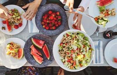 Mesa de picnic con ensalada con pasta y frutas Mesa de picnic con ensalada con pasta y frutas