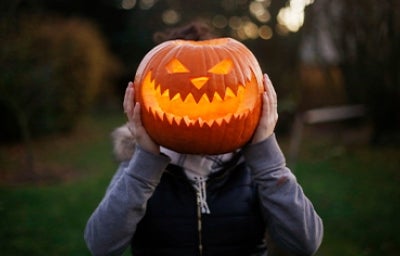 Calabaza de Halloween sobre el cuerpo de una persona. 