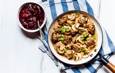 Carne en salsa de champiñones y perejil en una sartén.  
