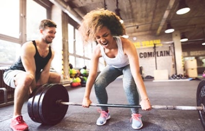 Una mujer y su entrenador haciendo entrenamientos de fuerza