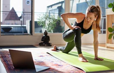 Mujer estirando en casa y haciendo ejercicios de cardio para principiantes Mujer estirando en casa y haciendo ejercicios de cardio para principiantes