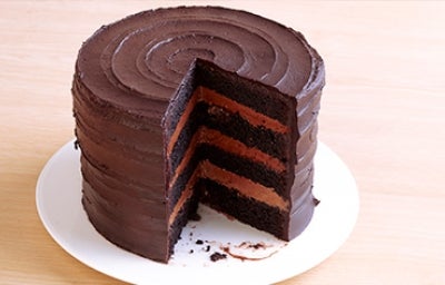 Una Tarta Sacher redonda con su interior descubierto sobre un plato blanco