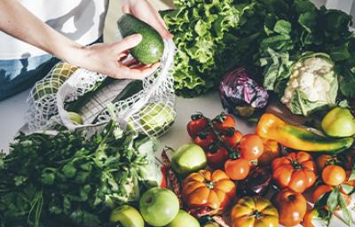 Una persona sacando productos orgánicos, frutas y verduras de una bolsa. Una persona sacando productos orgánicos, frutas y verduras de una bolsa.