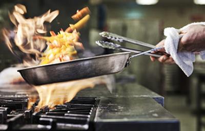 Sartén con fuego, importancia conocer primeros auxilios en la cocina 