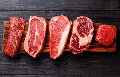 Cinco cortes para sellar la carne sobre una tabla de picar Cinco cortes para sellar la carne sobre una tabla de picar