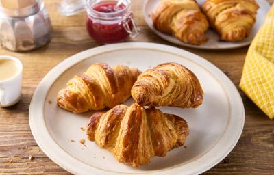 Croissant de almendra fresco. Tres deliciosos croissants de almendras frescos sobre un plato.