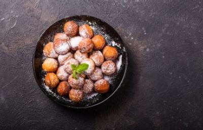 Buñuelos de yuca, una variable de los buñuelos tradicionales. Plato de buñuelos de yuca espolvoreados vistos desde un ángulo cenital.