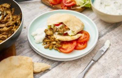 Gyro griego de pollo con tomates y salsa tzatziki Gyro griego de pollo en pan pita con tomates frescos y salsa tzatziki