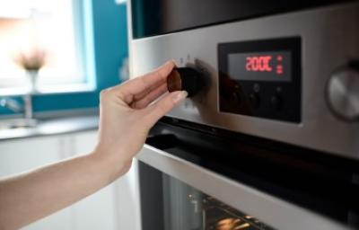 Persona ajustando temperatura en horno, termómetro de cocina Persona ajustando temperatura en horno, termómetro de cocina