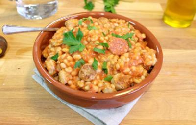 Cassoulet tradicional en cazuela con alubias y salchichas Cassoulet tradicional servido en cazuela de barro con alubias y salchicha