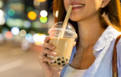 Perlas de tapioca, uno de los usos de la tapioca. Mujer disfrutando de una bebida complementada con perlas de tapioca.