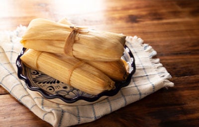 Plato con tres tamales de pescado envueltos perfectamente.