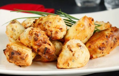 Plato lleno de buñuelos de bacalao recién cocinados.