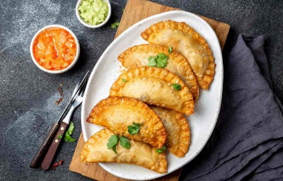 Platillo de empanadas de pescado con salsas de acompañamiento.