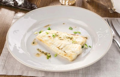 Filete de pescado blanco emplatado elegantemente.