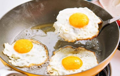 Sartén con tres huevos fritos cocinándose para acelerar metabolismo.