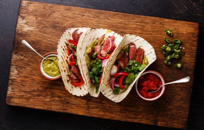 Tortilla de dieta llena de vegetales sobre tabla de picar. 