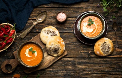 Sopa de tomate picante en mesa de madera.